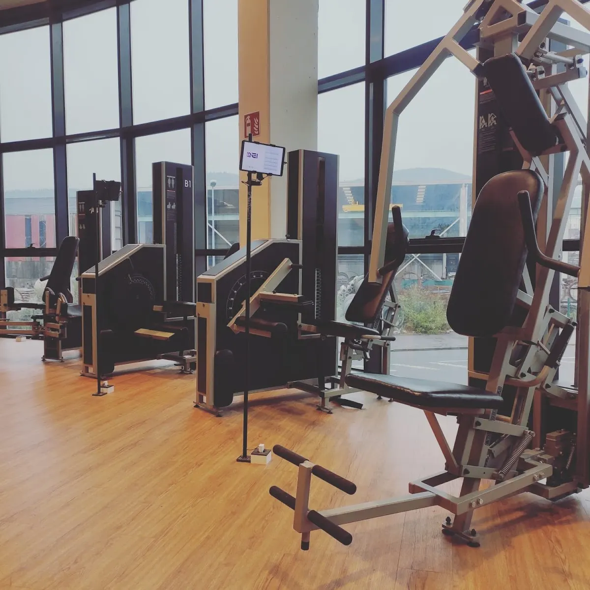 Máquinas de fuerza de SeiFitness Lab junto a los ventanales.