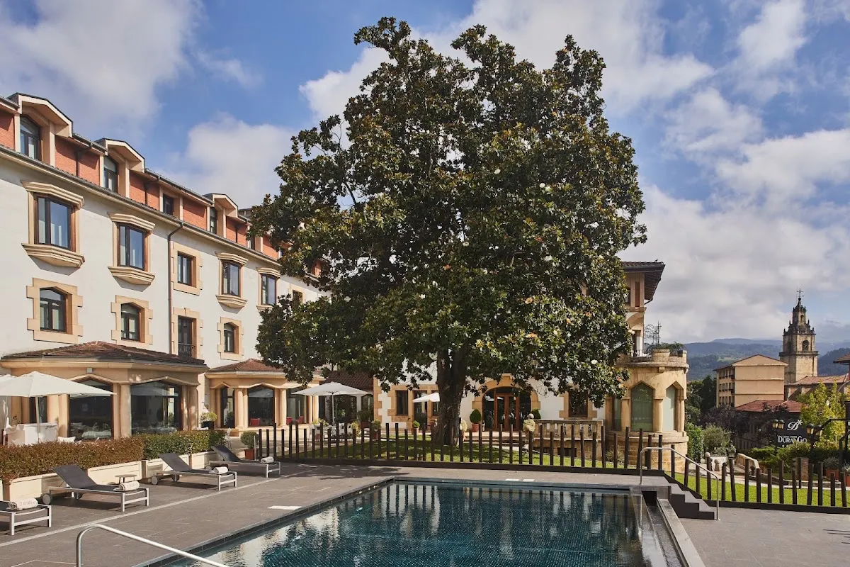 Piscina exterior y fachada del Silken Gran Hotel Durango, con vistas a Durango.