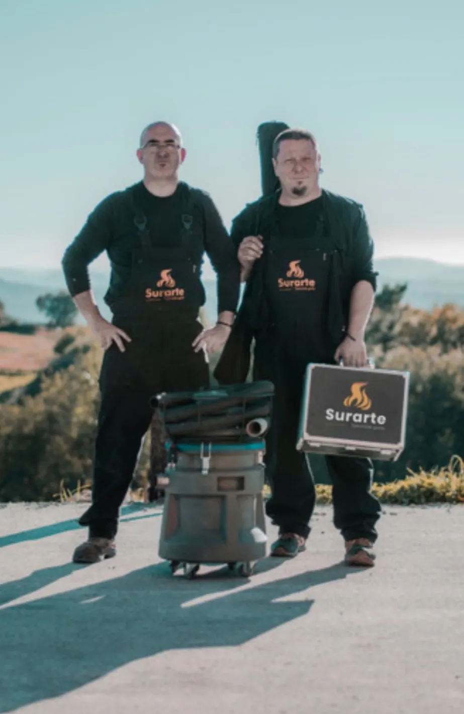 Dos trabajadores de Surarte junto a un equipo de limpieza en el exterior.