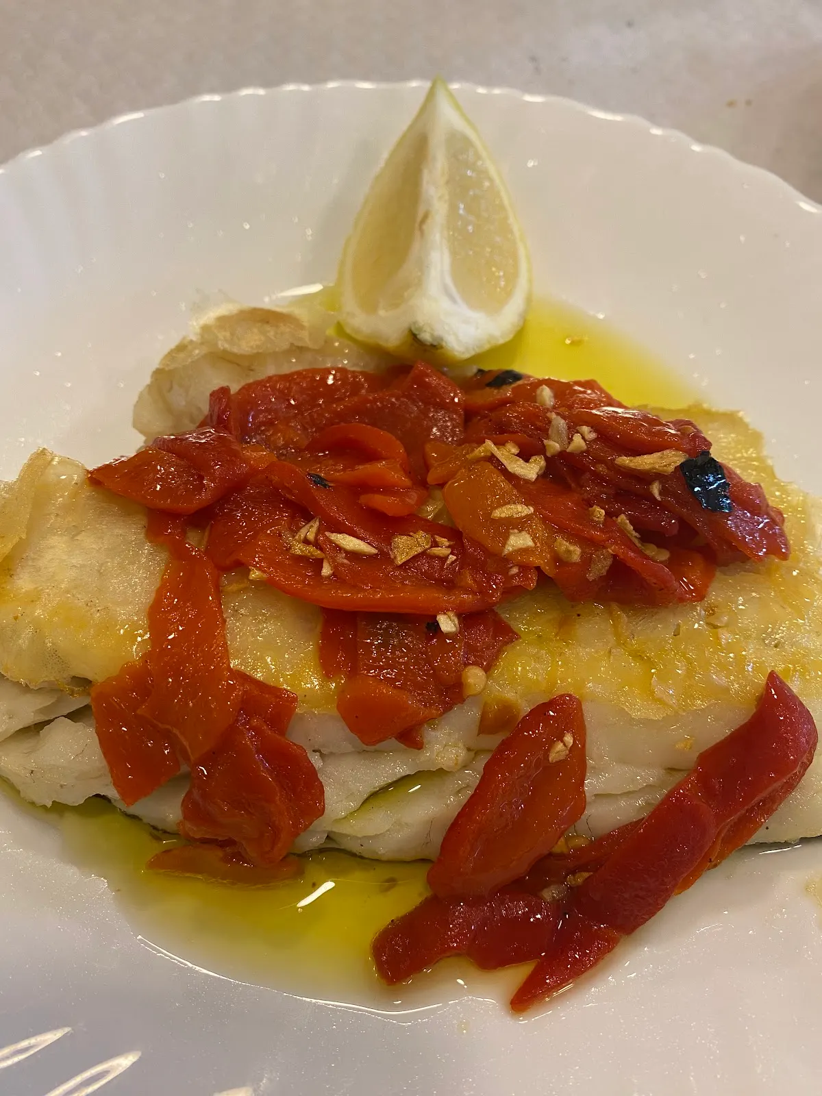 Plato de pescado con pimientos rojos y limón en Taberna Zarra