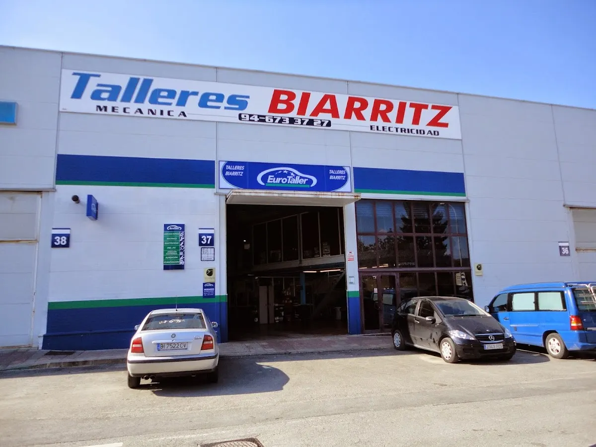 Exterior de Talleres Biarritz 37, con varios vehículos aparcados frente al taller.