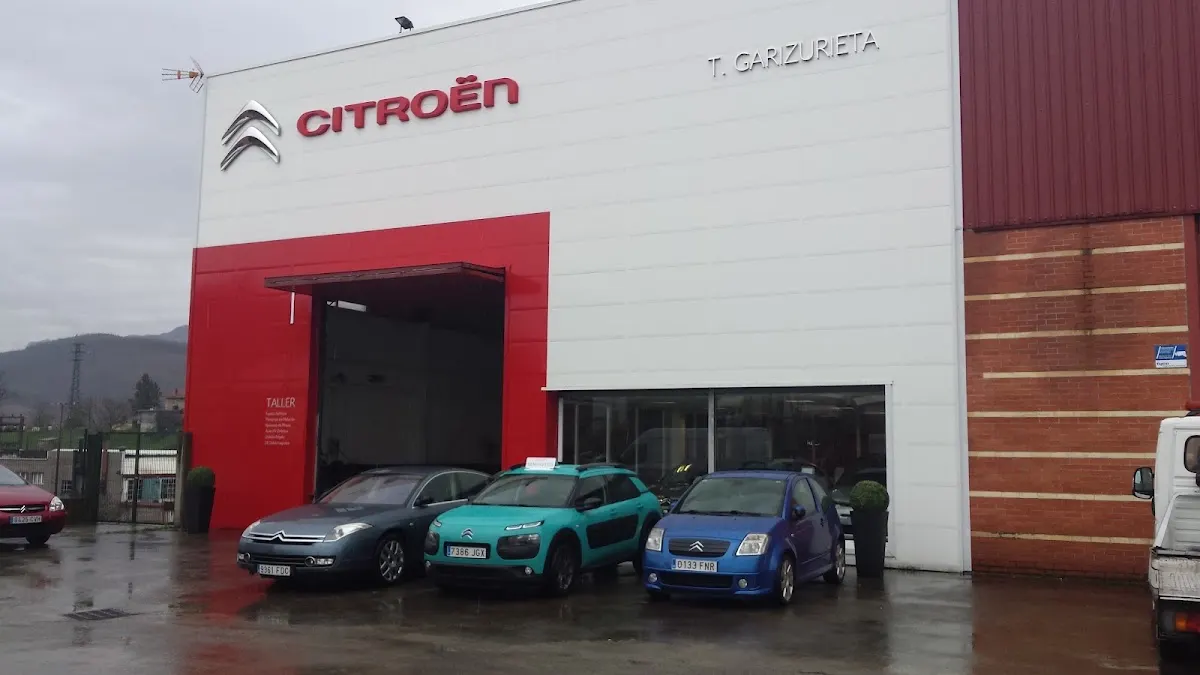 Fachada de TALLERES GARIZURIETA SL con el logotipo de Citroën y varios coches aparcados delante.