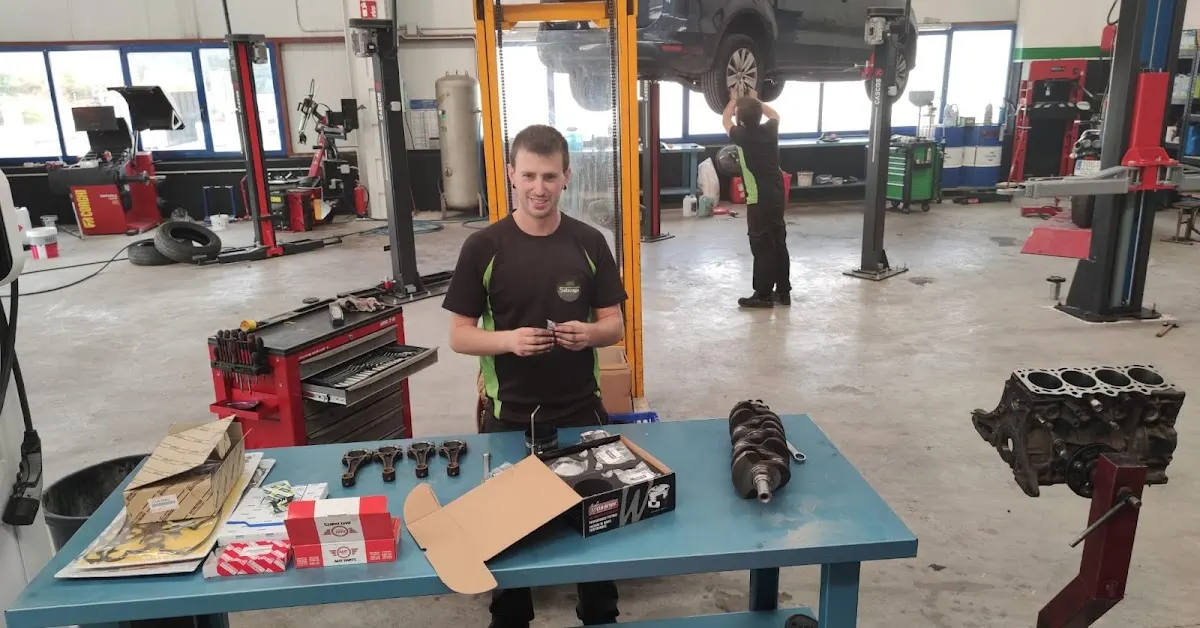Mecánico de Talleres Solazaga junto a piezas de motor en el taller.