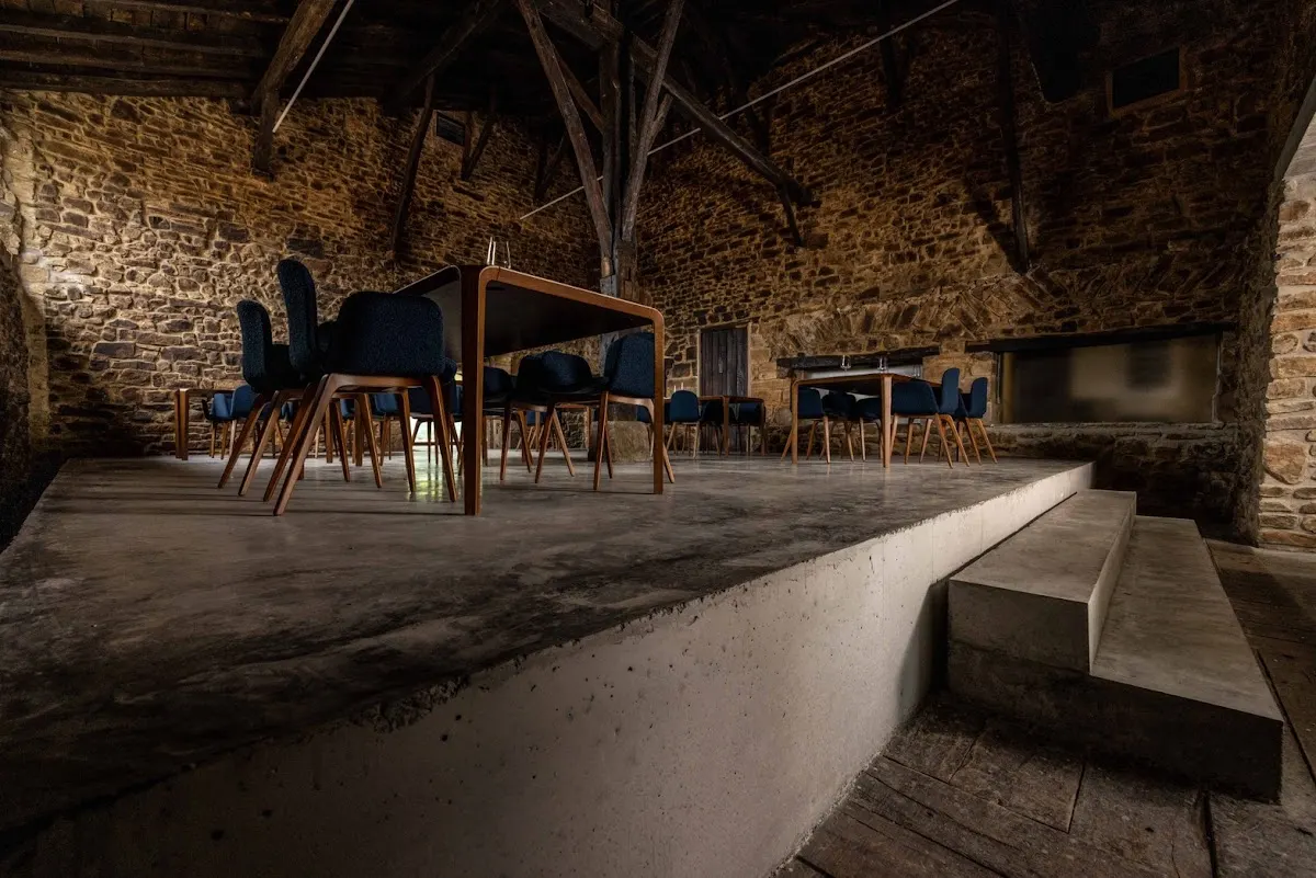 Sala de Txispa con mesas y sillas en un espacio de piedra y madera
