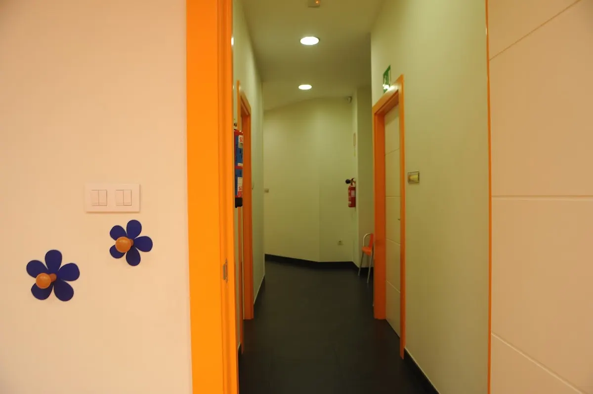 Pasillo interior de Ugatz con puertas de consulta y decoración de flores