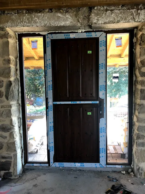 Puerta y ventanas de PVC en una fachada de piedra, Dicoven