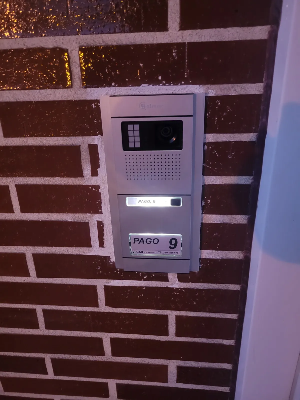 Portero automático instalado en una pared de ladrillo, en una imagen de Vi-Car Electrónica.