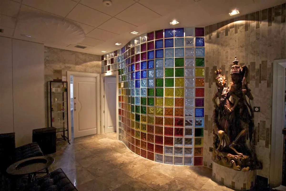 Recepción de Vilegy con una pared curva de bloques de vidrio de colores y una figura decorativa