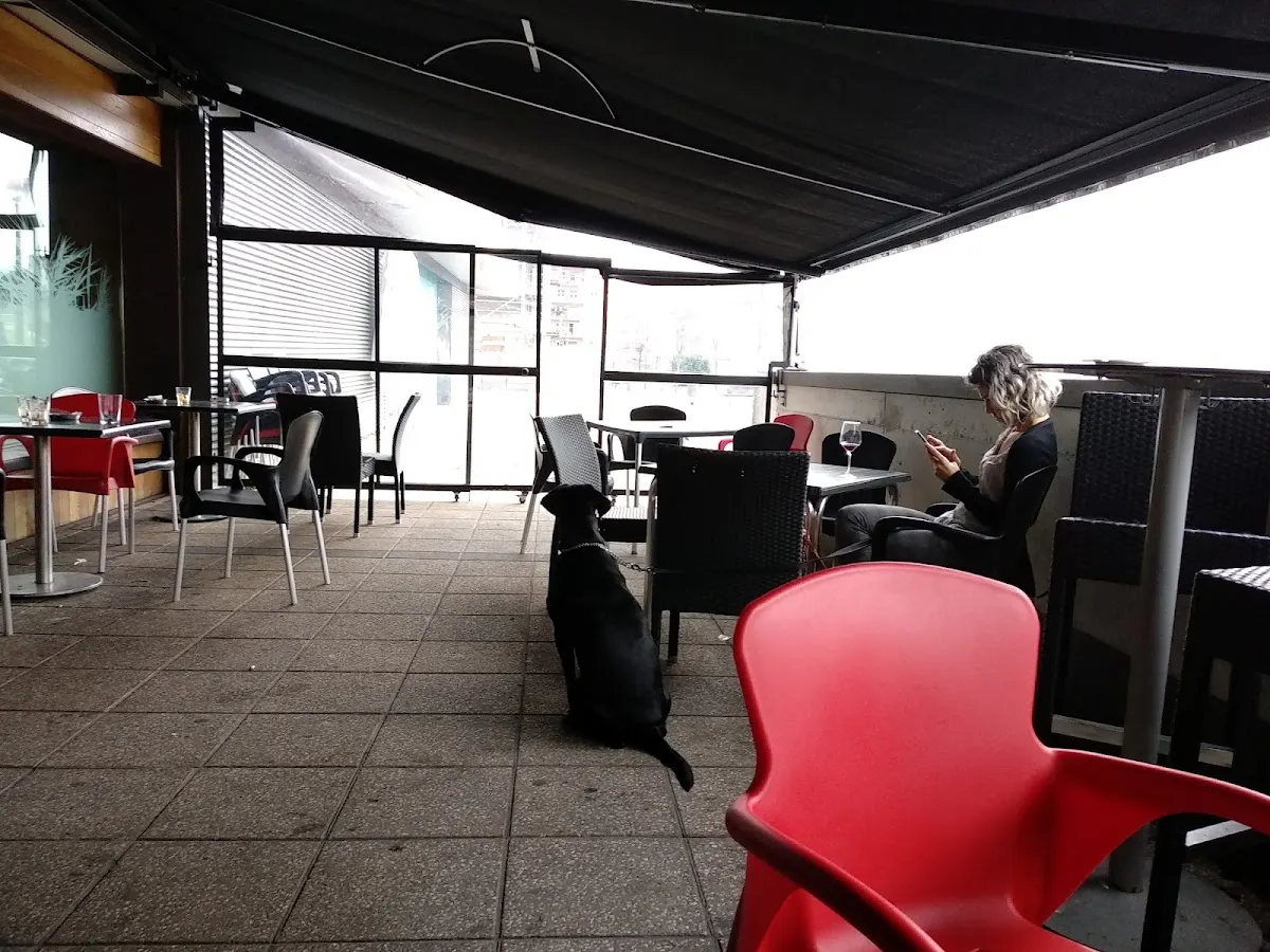 Terraza cubierta de Xelai Taberna, con mesas y sillas.