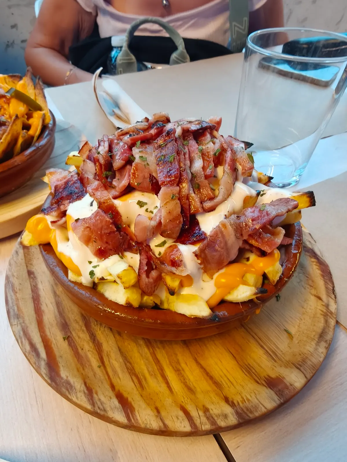 Ración de patatas con salsa y tiras de carne en Xelai Taberna.