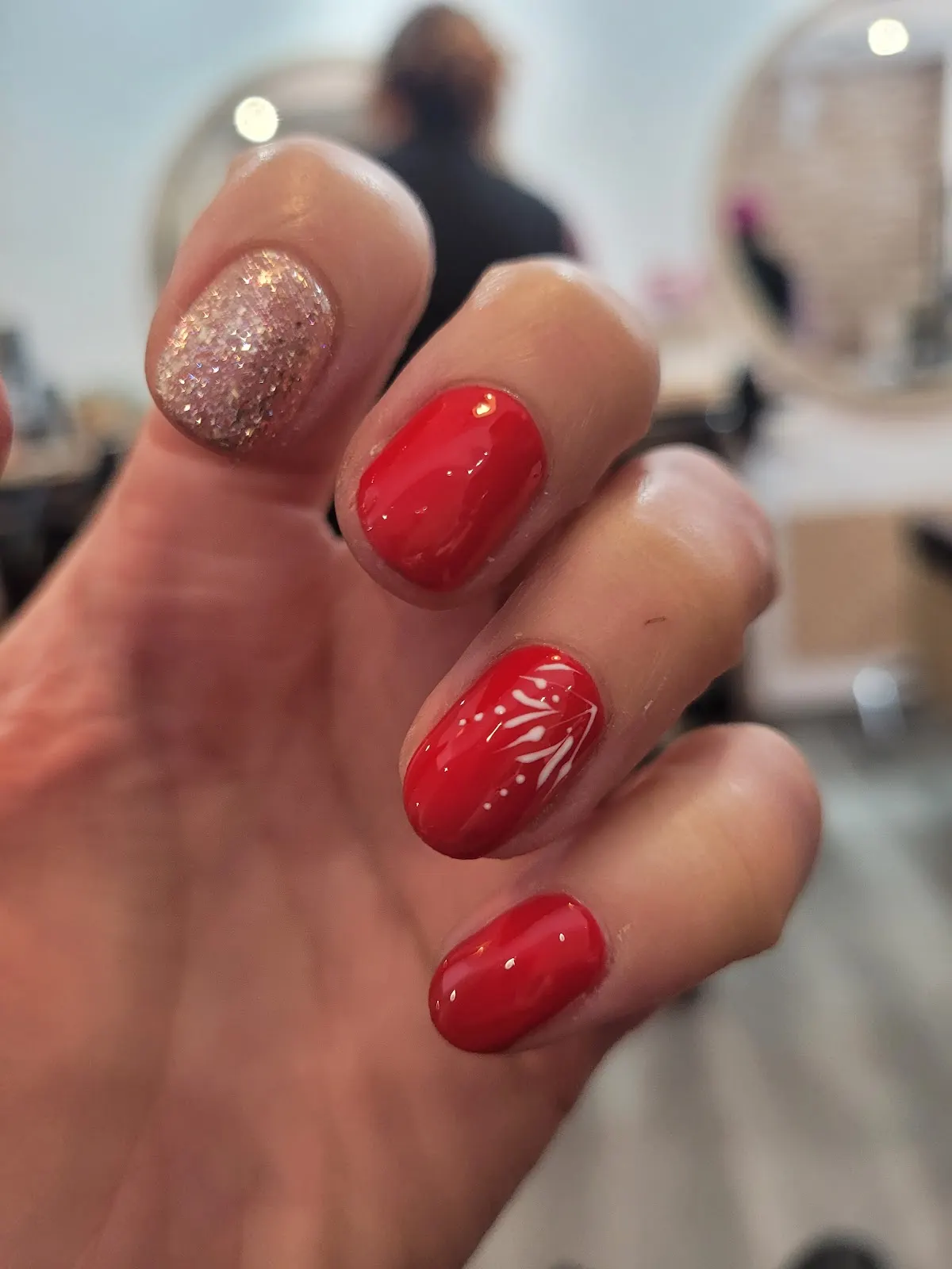 Uñas con esmalte rojo y detalle brillante.
