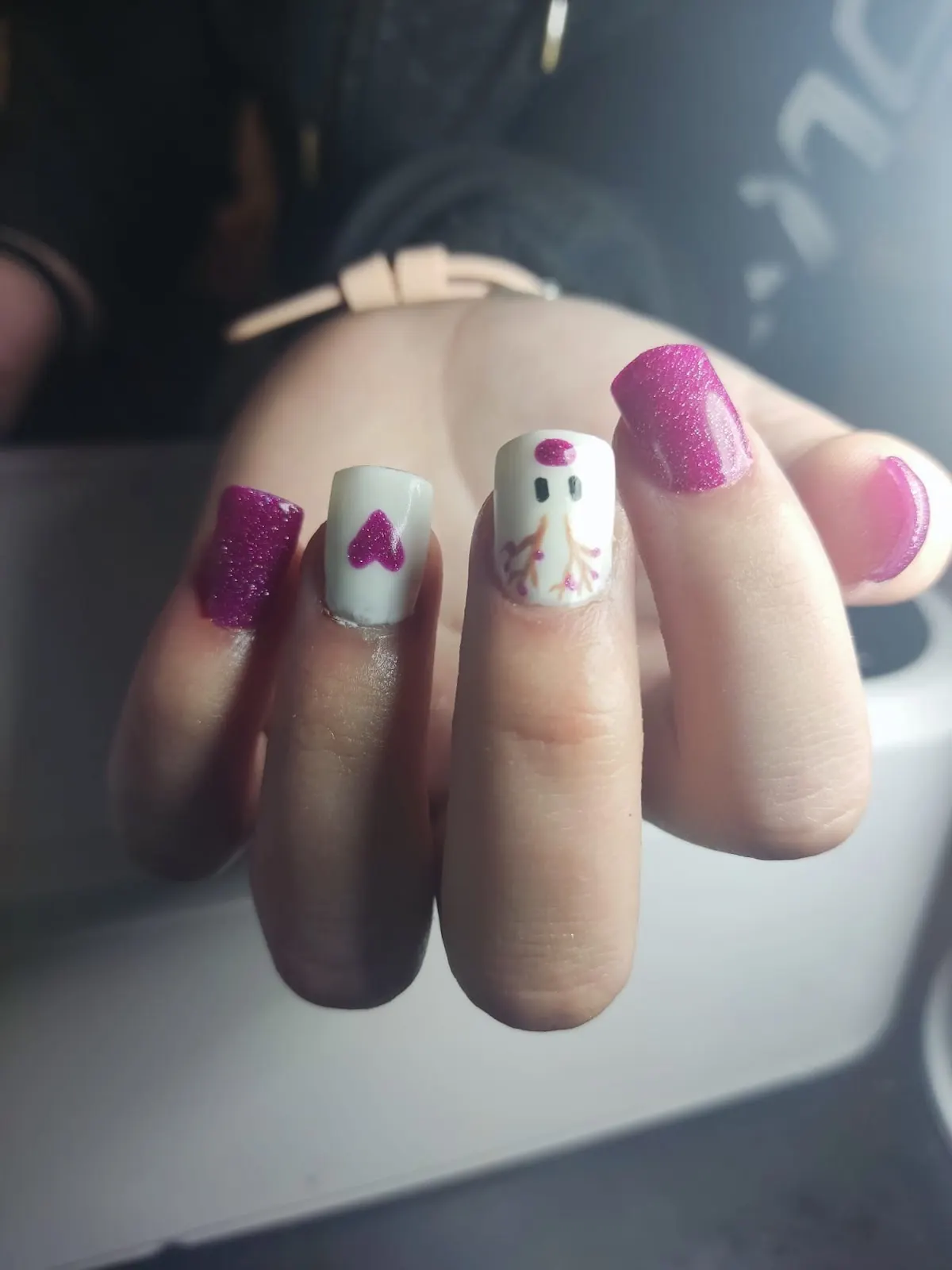 Diseños decorativos en uñas con esmalte rosa y blanco.