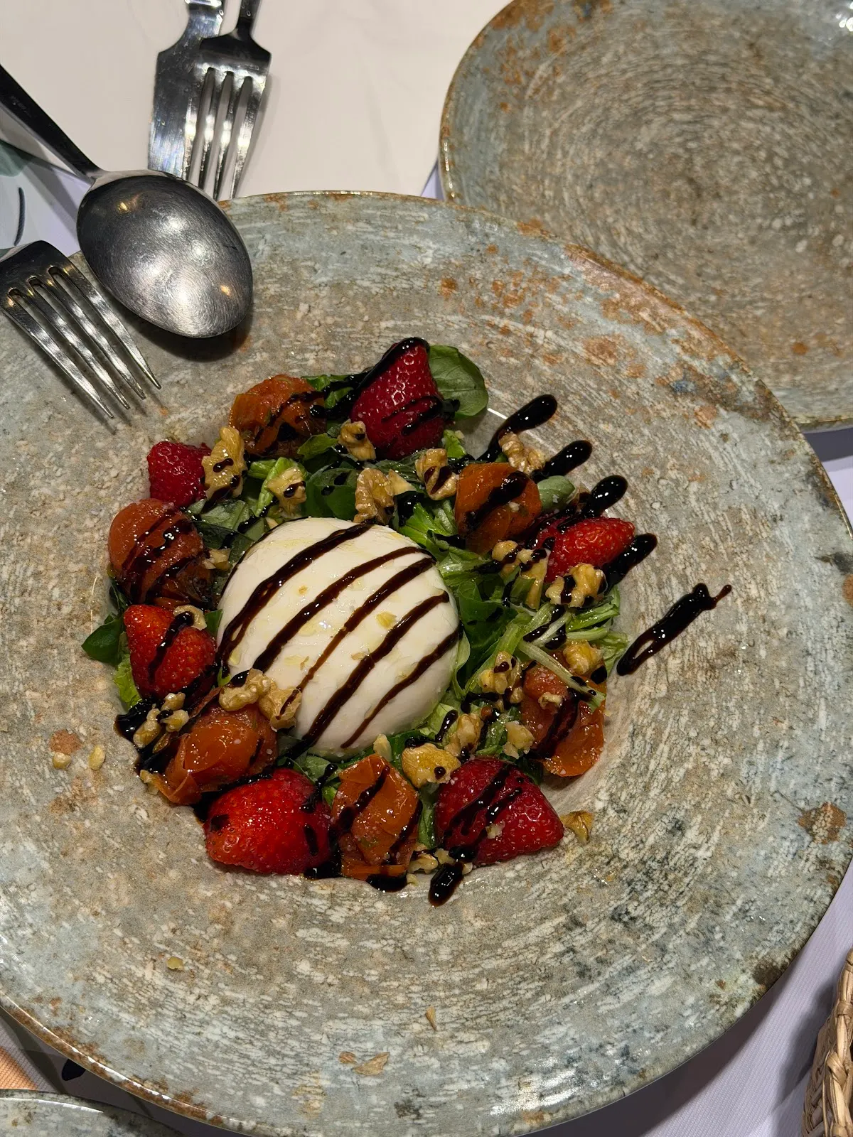 Plato de postre con helado, fruta y salsa de chocolate en XIXILU.