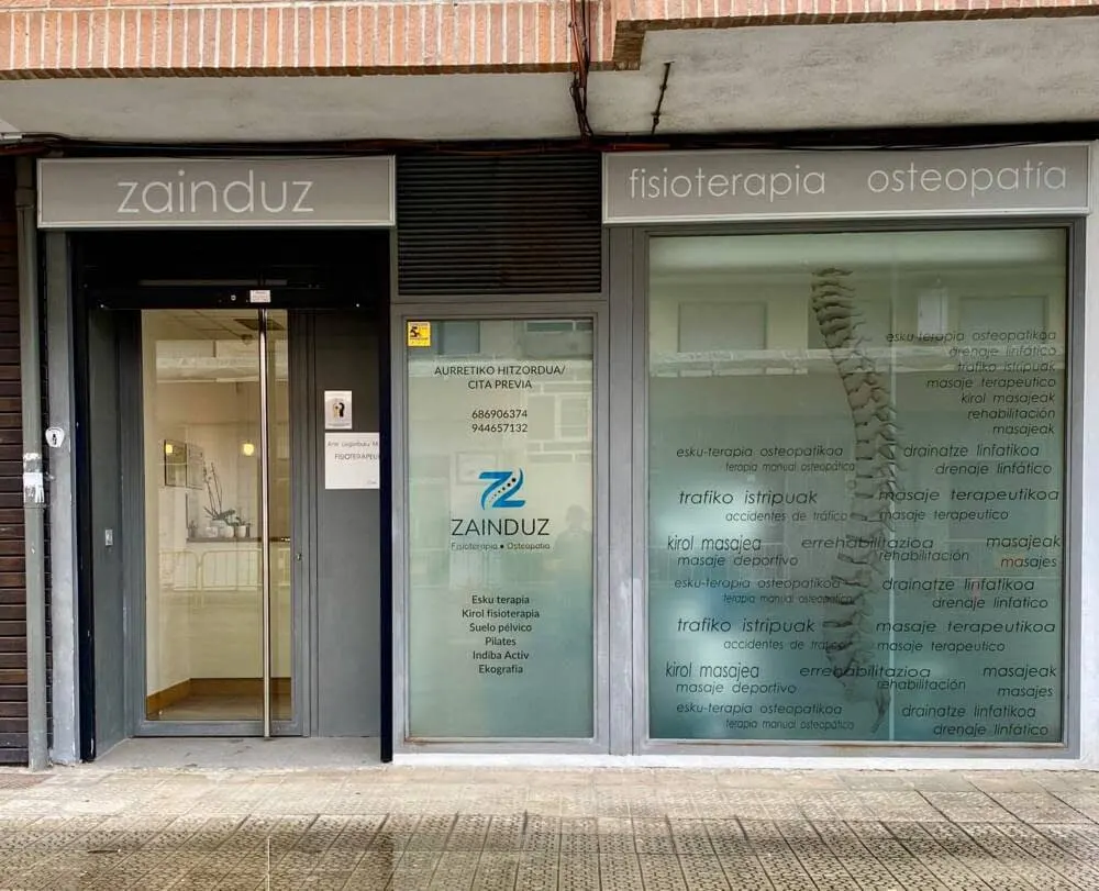Entrada de Zainduz Fisioterapia Osteopatía en Abadiño, con rótulos de fisioterapia y osteopatía.