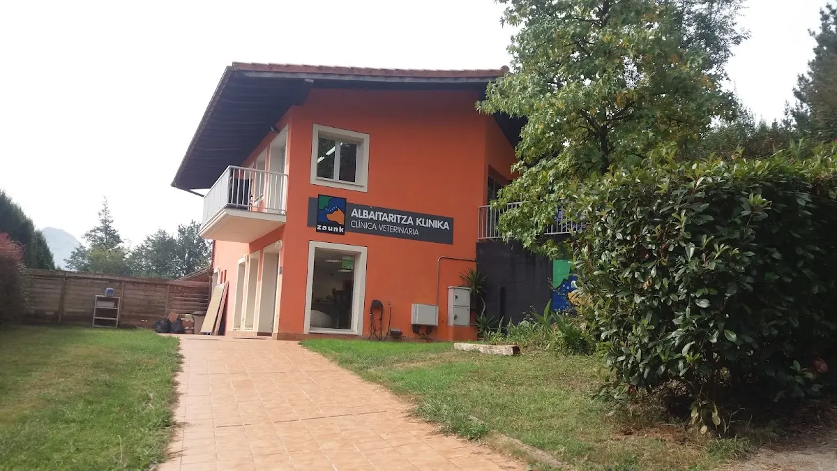 Edificio naranja de ZAUNK en Iurreta, rodeado de jardín.