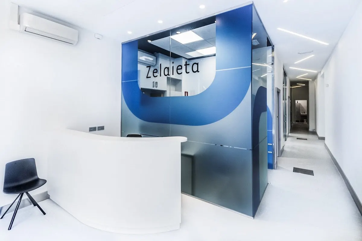 Recepción de Zelaieta Hortz Klinika, con mostrador blanco y rótulo azul.