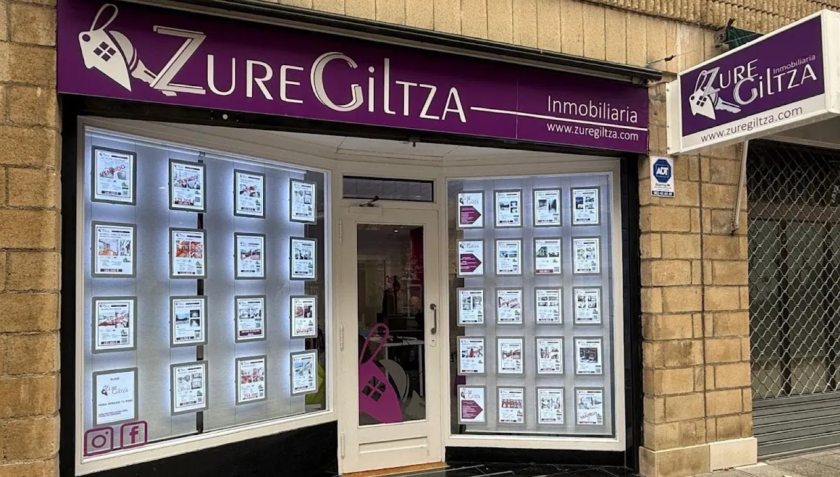 Fachada de la inmobiliaria Zure Giltza con escaparate de anuncios inmobiliarios