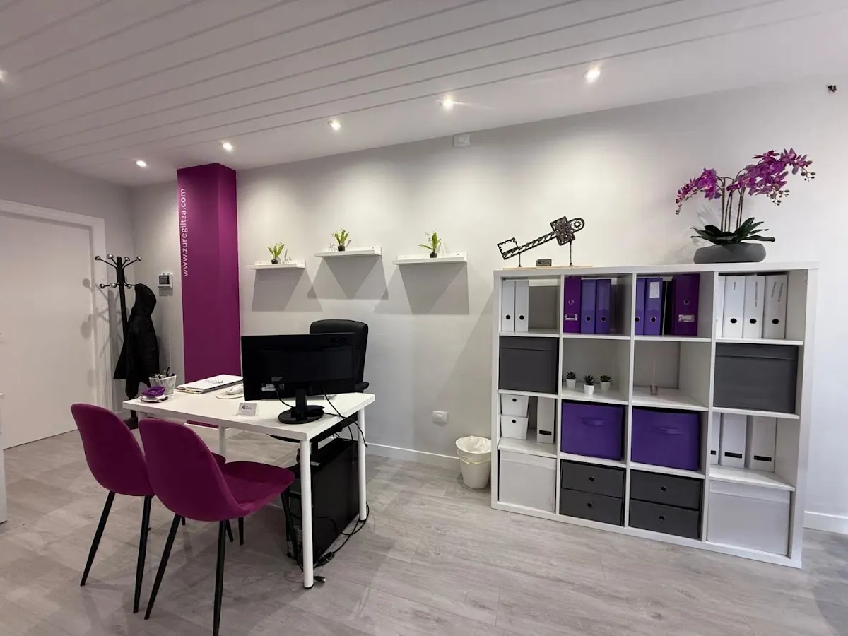 Interior de la oficina de Zure Giltza con mesa de atención y estanterías