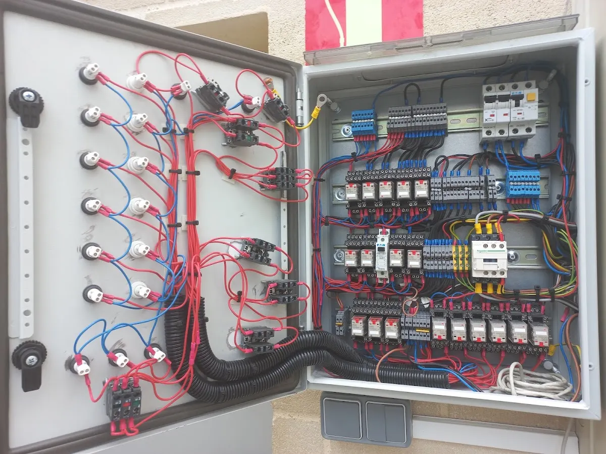 Cuadro eléctrico abierto con cableado, interruptores y componentes de control.